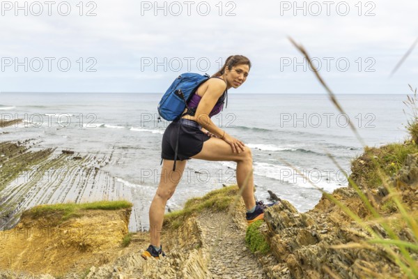 Female hiker enjoying the scenic view of the sakoneta beach and flysch cliffs in zumaia, basque