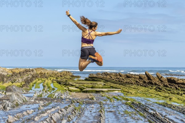 Celebrating freedom and athleticism, a woman leaps with joy amidst the unique geological formations