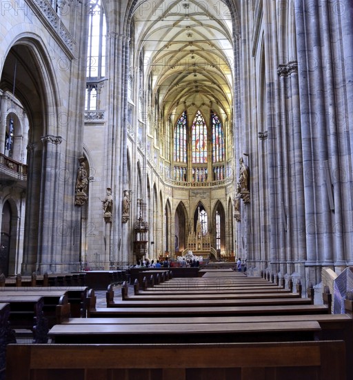 Tourists admiring the stained glass windows and gothic architecture of st. Vitus cathedral in