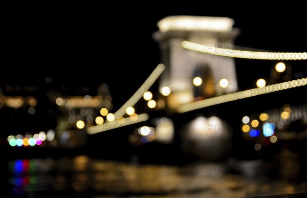 Blurred lights highlighting the chain bridge in budapest, hungary at night, reflecting in the
