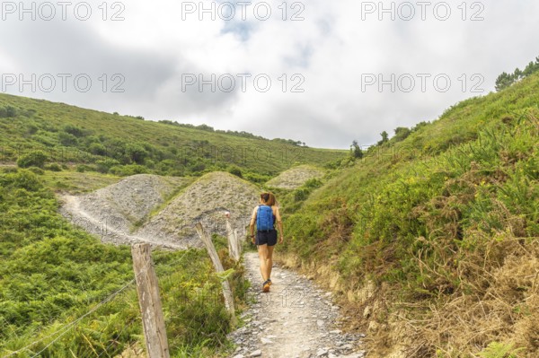 Female tourist walking on a hiking trail exploring the beautiful landscape near sakoneta beach in