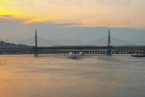 Long exposure of a metro train crossing the golden horn metro bridge in istanbul, turkey, during a