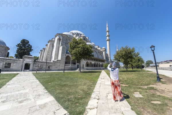 Tourist capturing stunning images of suleymaniye mosque in istanbul on a bright, sunny summer day,