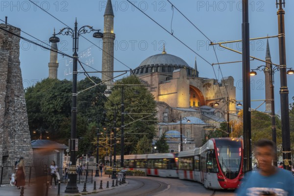 Modern tram passing in front of the ancient hagia sophia mosque in istanbul, turkey, during a