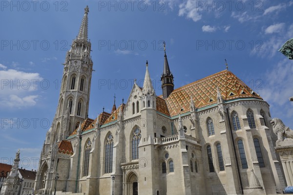 Matthias church with its colorful roof tiles and tall bell tower standing tall against a blue sky