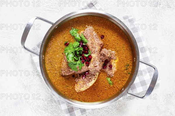 Fesenjan, an Iranian dish, stewed chicken, in a nut-pomegranate sauce, in a saucepan, light