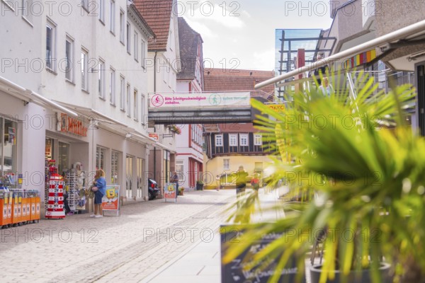 Modern shopping street with shops and passers-by on a sunny day, small town Perle Calw, Black