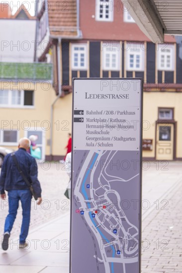 Signpost in a picturesque old town with half-timbered houses in the background, small town pearl