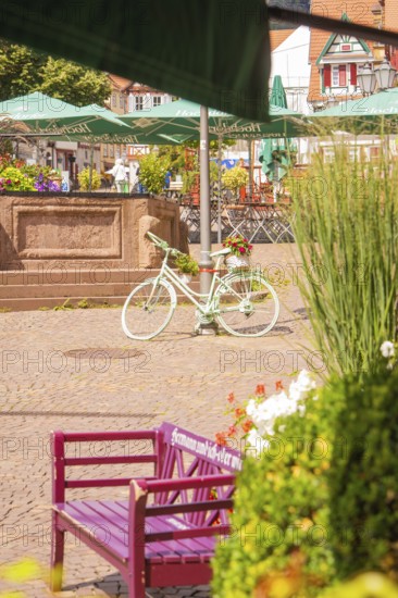 A sunny square with a decorative bicycle and flowers, small town pearl Calw, Black Forest, Germany