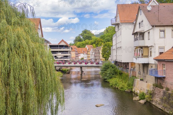 Bridge over a river with hanging willows and neighbouring town buildings, small town of Perle Calw,