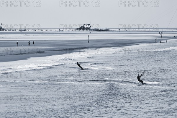Two kitesurfers in the evening, monochrome, Sankt Peter-Ording, Eiderstedt peninsula, Wadden Sea