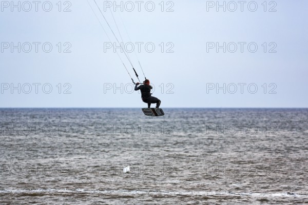 Kitesurfer jumping, Sankt Peter-Ording, Eiderstedt peninsula, Wadden Sea National Park, North Sea,