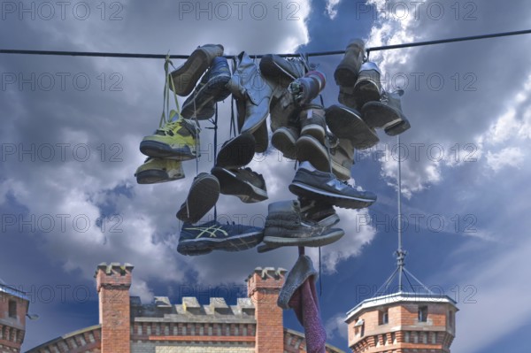 Shoes hanging on a leash in the courtyard of a residential home for addicts, each shoe a reminder