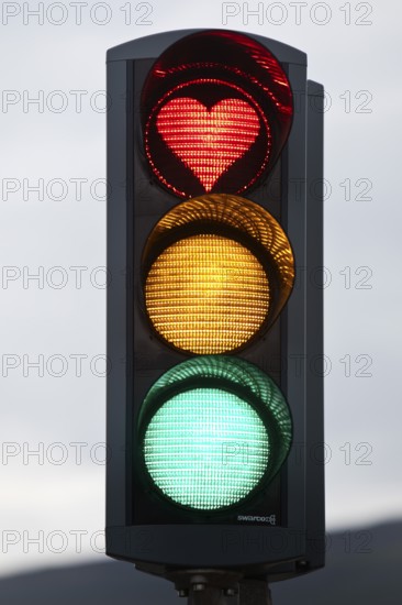 Traffic lights with green light, yellow light and red light in the shape of a heart, symbolic image