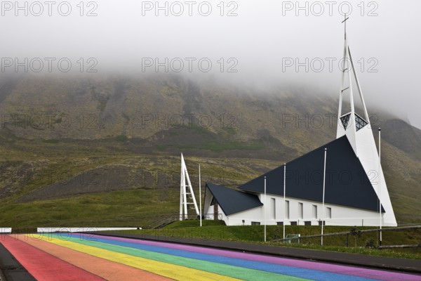 Street painted in the colours of the rainbow and the fish-shaped church designed by Hákon
