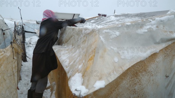 Displaced Syrian families and children living in refugee camps during harsh winter conditions,