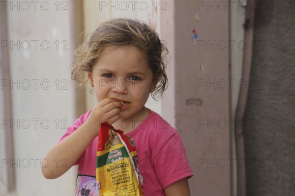 A Syrian refugee child photographed in a camp, reflecting the harsh living conditions of displaced