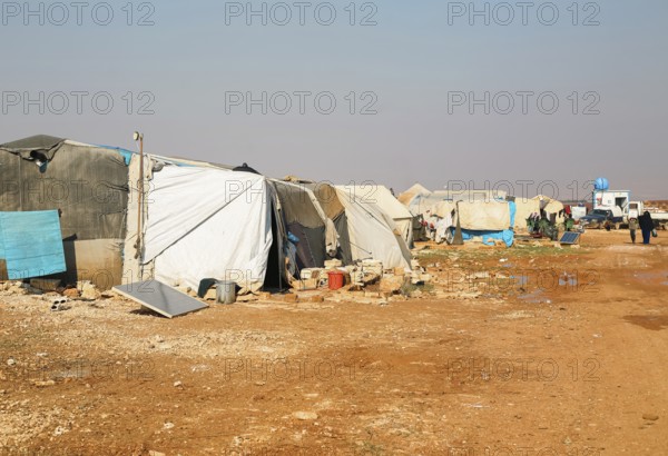 Worn-out tents housing Syrian refugees near the Turkish border, showing the dire humanitarian