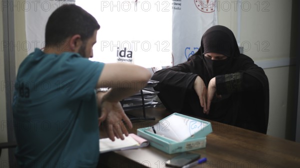 A doctor examining a woman inside a mobile medical point dedicated to treating Syrian refugees.
