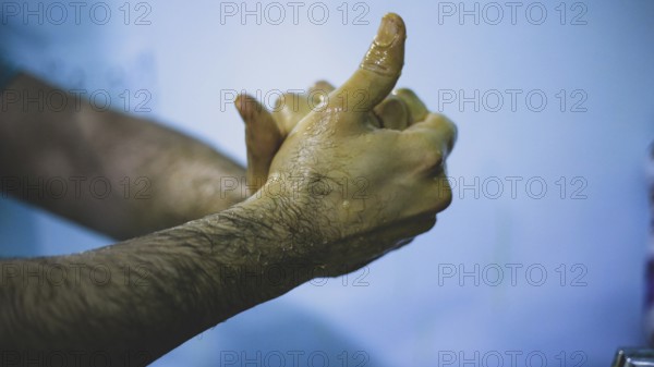 A doctor washing his hands before entering the operating room to perform surgery. Aleppo, Syria