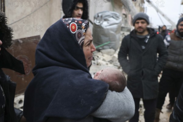 A frightened mother carries her infant after he was pulled from the rubble of a deadly earthquake