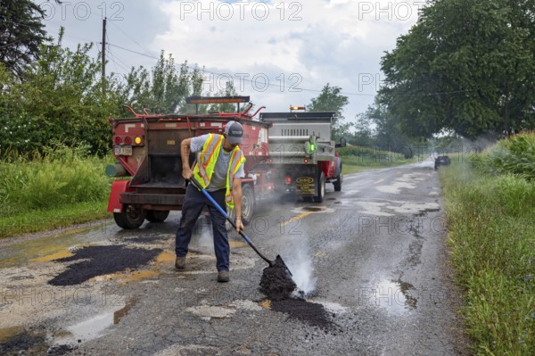 Glendora, Michigan - A worker for the Berrien County Road Department patches potholes on Wagner