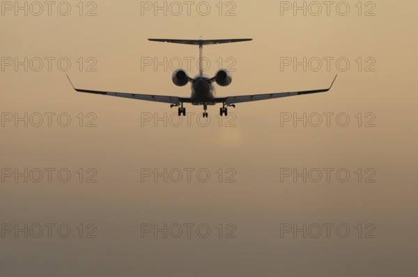 Executive business jet passenger aircraft landing at sunset, London Stansted airport, Essex,