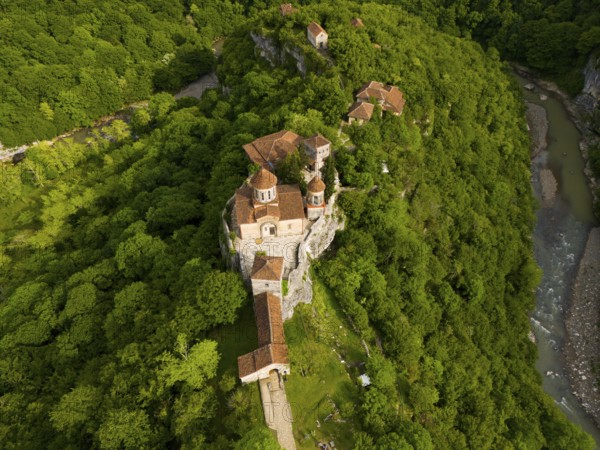 Aerial view of a monastery in the middle of a green forest, near a river, aerial view, Motsameta