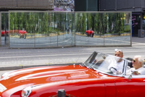 Mirror in front of the Kunsthalle Mannheim. Distorted vehicles are reflected in the glass.