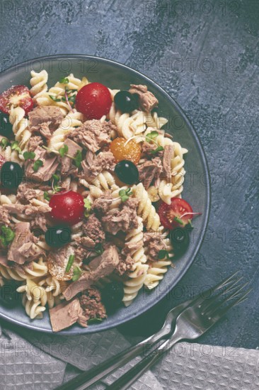 Fusilli pasta salad with canned tuna, cherry tomatoes and olives, parmesan, microgreens, homemade,
