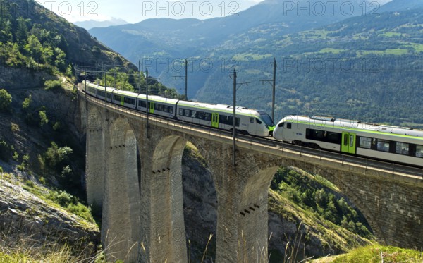 Two coupled RABe 528 multiple units of the BLS AG railway company cross the Luogelkin Viaduct on
