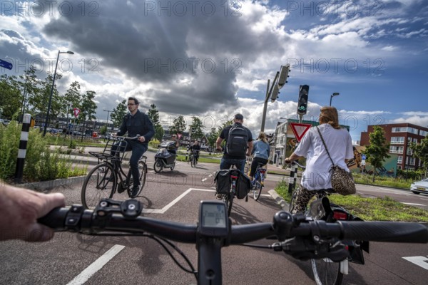 Cycling in the Dutch city of Utrecht, cycle path separated from the carriageway for cars, heavy