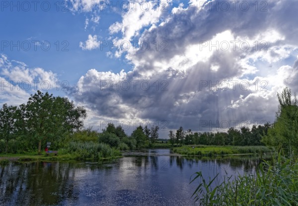 Sun and clouds over the River Trave in Brenner Moor. The Brenner Moor is a salt moor, FFH area, in