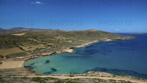 Bay of Vai, coast with crystal blue water, surrounded by hilly landscape under a clear sky,