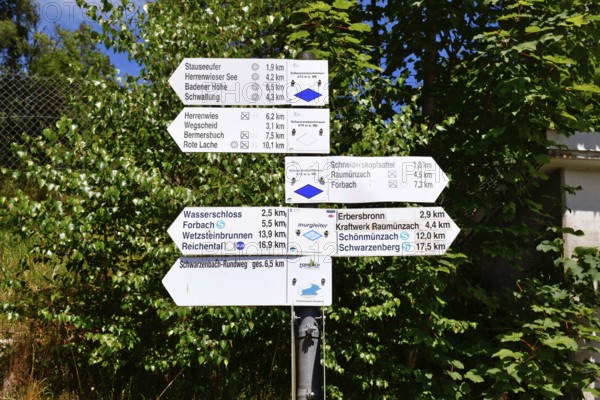 Hiking trail signpost in Forbach, Black Forest, Germany showing directions and distances to nearby