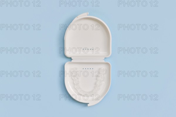 Customized transparent dental teeth bite guard clear aligners for lower jaw in white case on blue