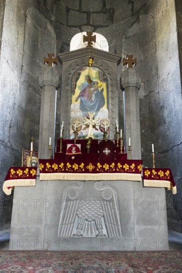 Church altar with religious symbols and icon, decorated with red cloths and candles, Sisian,