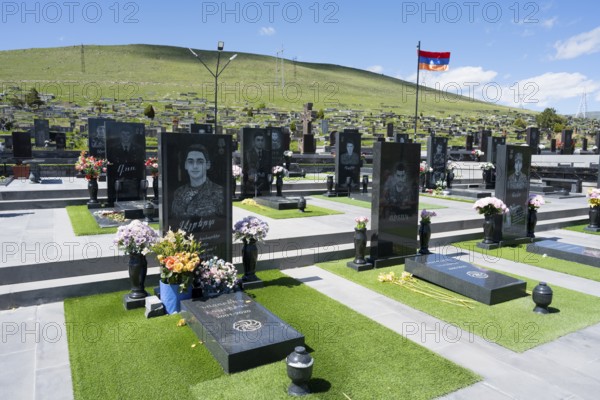 Cemetery with memorial plaques and flowers, peaceful atmosphere under a blue sky, graves of 2020,