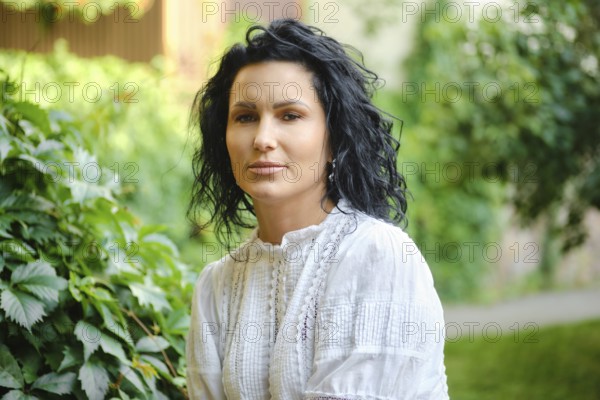 Bright and peaceful atmosphere surrounds a woman with curly black hair as she sits gracefully among