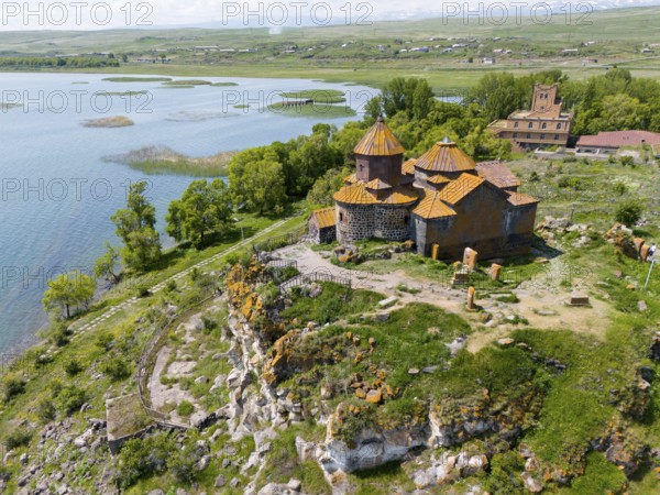 Historic church on a cliff with a surrounding green landscape and a lake, aerial view, Hajrawank
