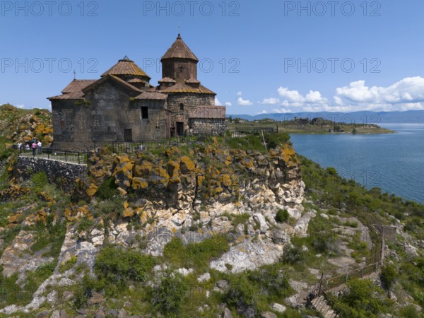Historic church on a hill overlooking a lake under a bright blue sky, aerial view, Hajrawank