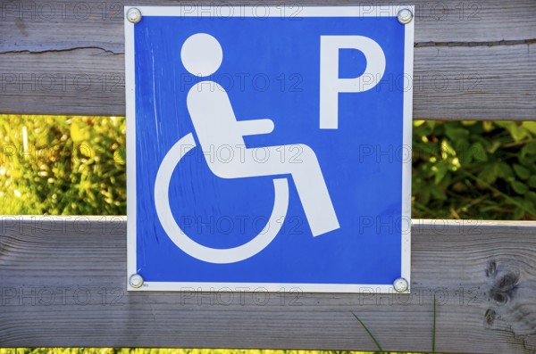 Sign with pictogram Car park for the disabled on a wooden fence, near Henan on Orust, Bohuslän,