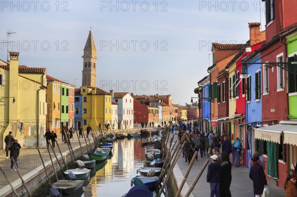 Strollers along the canal, typical street scene in winter, campanile of the church of San Martino,