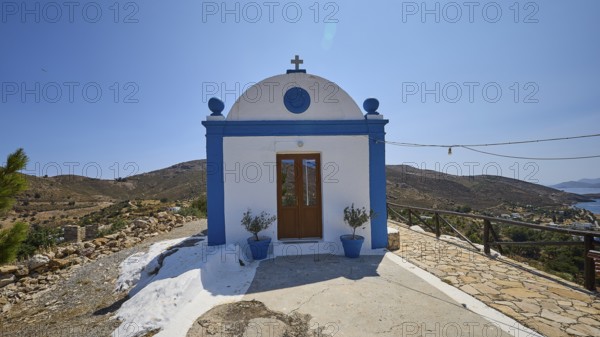 White and blue chapel in a rural area with views of the sea and surrounding hills, Panagia tou