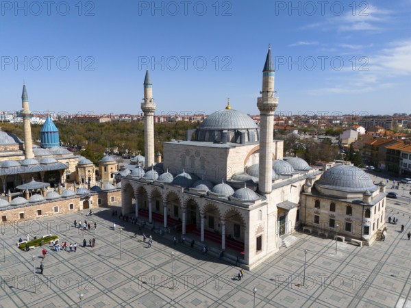 Spacious mosque complex with wide squares and several minarets under a clear sky, aerial view,
