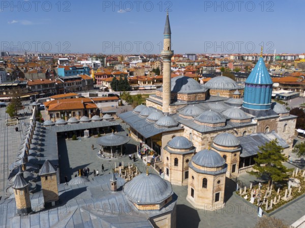 Historic mosque with large domes and minarets in the city centre under a clear sky, aerial view,