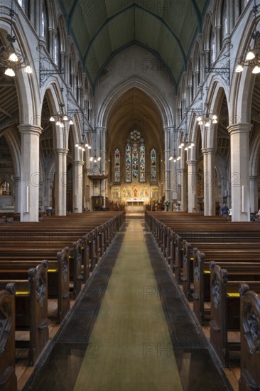 Neo-Gothic church interior with high arches and wooden benches, St Mary Abbot Church, Kensington,