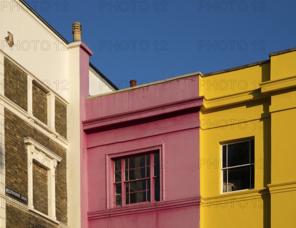 Colourful building facades in pink, yellow and white, blue sky, Portobello Road, Notting Hill,