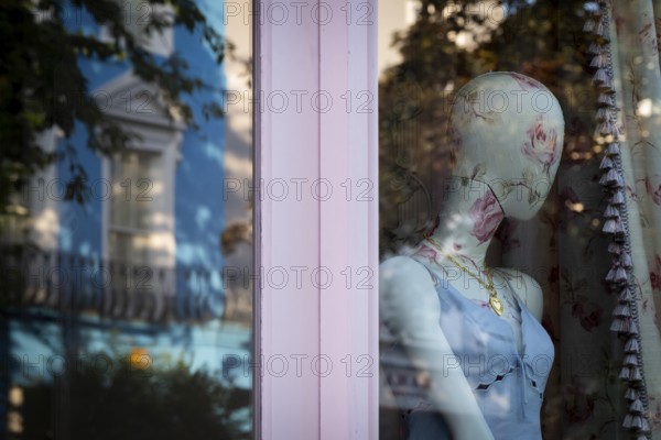 Mannequin in floral pattern, reflection in shop window, Portobello Road, Notting Hill, London,