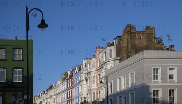 Terraced houses, townhouses with different, colourfully painted facades under a blue sky,